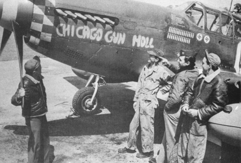 Die einzige bekannte Aufnahme der "Chicago Gun Moll" zeigt Captain Brown inmitten seiner Flugzeugwarte. Brown hatte zu jenem Zeitpunkt zwei deutsche Flugzeuge abgeschossen, wie an den beiden Hakenkreuzen unter dem Cockpit zu erkennen ist. (369_1)